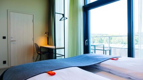 a bedroom with a bed and a large window at Citybox Kristiansand in Kristiansand
