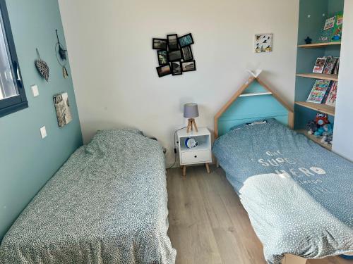 - une chambre avec 2 lits et une horloge murale dans l'établissement Villa entre Océan et Bassin, piscine chauffée, à Lège-Cap-Ferret