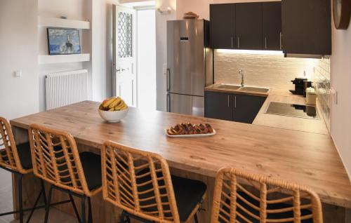 a kitchen with a wooden table and chairs at Andros Neoclassical Villa NP1926 with Private Pool in Steniaí