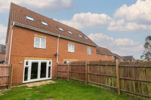 a red brick house with a wooden fence at Host & Stay - Bluebell Close in Northampton