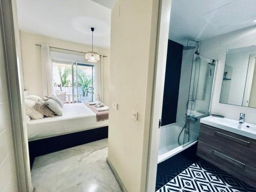 een badkamer met een bed, een bad en een wastafel bij Apartamento Golf Valle Romano in Estepona