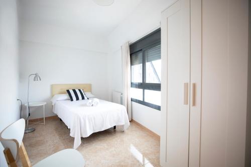 una camera da letto bianca con un letto e una finestra di MontePerdido ad Aínsa