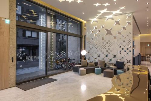 a lobby with couches and chairs in a building at Ramble Hotel in Taichung