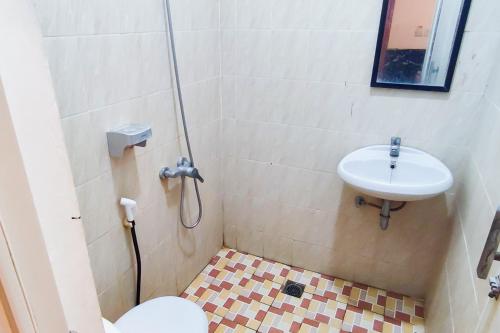 a bathroom with a toilet and a sink at Urbanview Hotel Dream Guesthouse Padang in Kampungdurian
