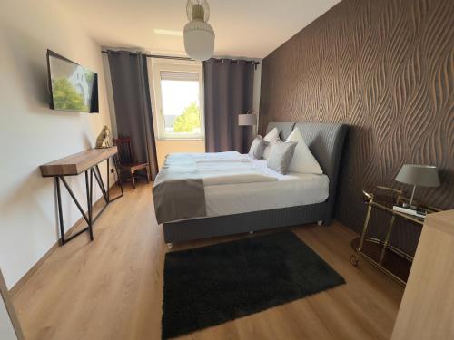 a bedroom with a bed and a desk and a window at Pension Stadt Mannheim in Mannheim