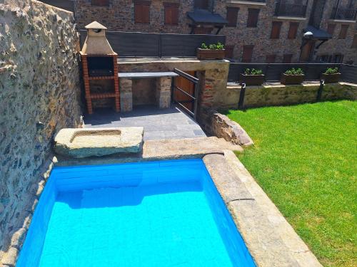 a swimming pool in a yard with a bench at Apartament "El Castell" Casa Rural Cal Rialla in Llivia