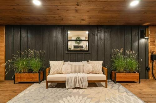 a couch in a room with two potted plants at Modern Mountain Retreat in Gatlinburg