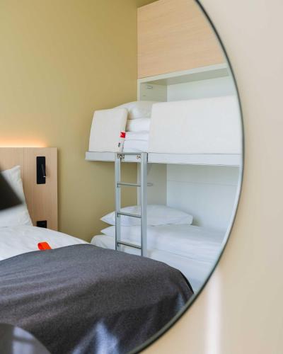 a mirror reflection of a bedroom with bunk beds at Citybox Kristiansand in Kristiansand