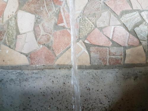 a stream of water coming out of a stone wall at Villa BS Sarajevo in Sarajevo