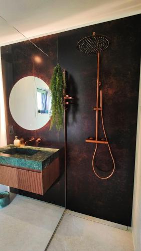 a bathroom with a sink and a mirror at Logement insolite miroir dans la nature avec hottub in Ohey
