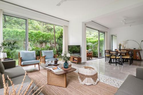 an open living room with a table and chairs at La Olalian 2 & 3 BHK Designer Villas Near Anjuna Beach with Private Pool & Sun Deck & Garden in Anjuna