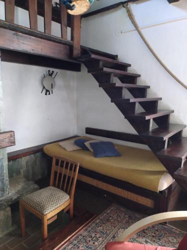a room with a bed and a staircase with a chair at Chata Pavla in Jablonec nad Nisou