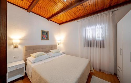 une chambre avec un lit blanc et une fenêtre dans l'établissement Villa Jadranka by Villas Guide, à Otočić Ošjak