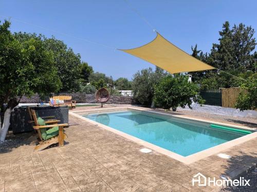 a swimming pool in a yard with a umbrella at Venecia of Mani - Relax in a spa pool in Loukísia