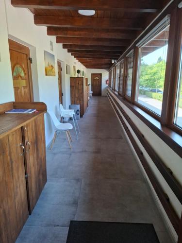 a hallway of a building with windows and chairs at Beachfront Apartman in Balatonfůzfő