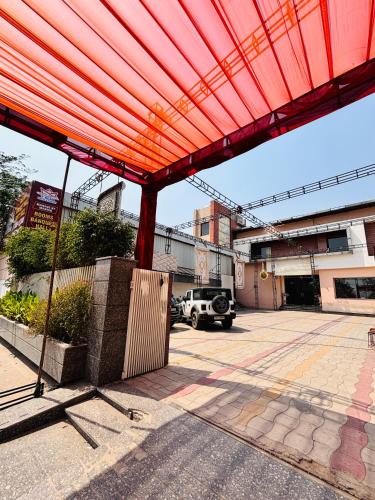 a large red covering over a parking lot at Hotel Osis in Baddowāl