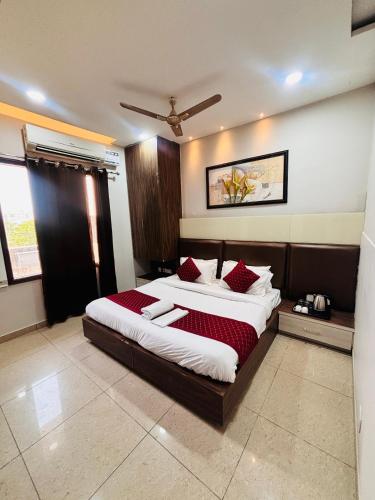 a bedroom with a large bed with red pillows at Hotel Osis in Baddowāl