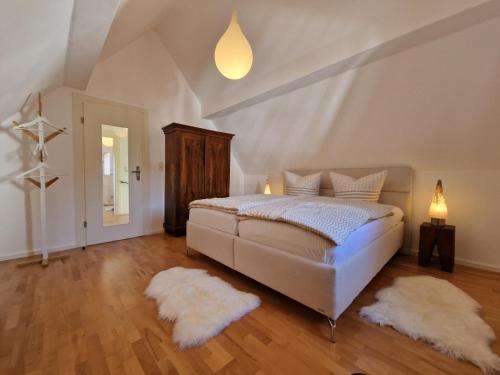 a bedroom with a bed and two white rugs at Ferienhaus Anna mit Kamin, Terrasse, Hof & Garage in Haßloch