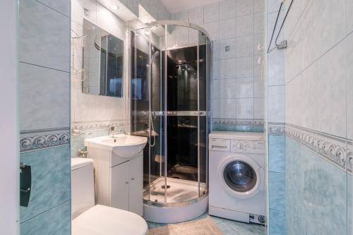 ein Badezimmer mit Waschmaschine und Waschmaschine in der Unterkunft Laguna Apartment - 1 km to Baltic Sea & 15 Minutes to Gdańsk Old Town in Danzig