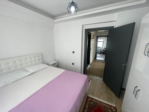 a bedroom with a white bed and a black door at Duplex house with panoramic view in Gökçeada