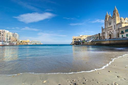 a view of a beach with buildings and the ocean at 248 Boutique Studios, Sliema in Sliema