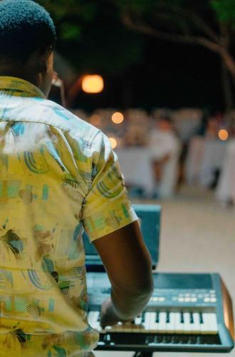 a man sitting at a table with a laptop computer at Pearl Beach by Sansi in Michamvi