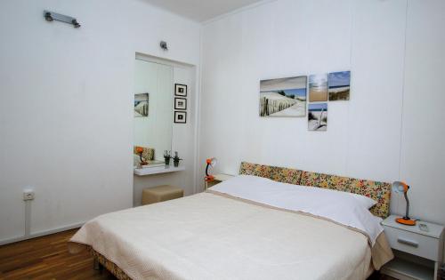 a white bedroom with a bed and pictures on the wall at Apartment Inge in Split