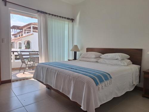 Schlafzimmer mit einem Bett und Blick auf einen Balkon in der Unterkunft Tortugas dos cero uno in Puerto Escondido