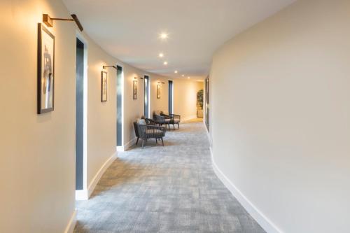 a hallway with chairs and tables in a building at voco Fareham - Solent by IHG in Fareham