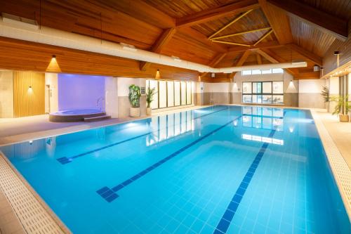 a large swimming pool with blue water at voco Fareham - Solent by IHG in Fareham