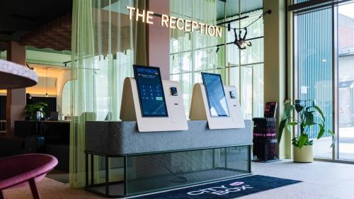 a display in a lobby with two monitors on a counter at Citybox Kristiansand in Kristiansand