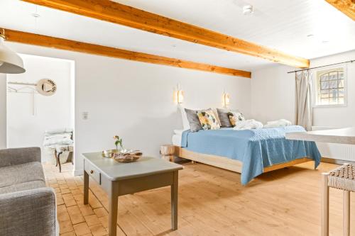 a bedroom with a bed and a couch and a table at Solbjerggaard Bed & Breakfast in Fåborg