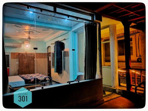 a room with a bedroom with a bed and a mirror at Shri Ganga View Guest House in Rishīkesh