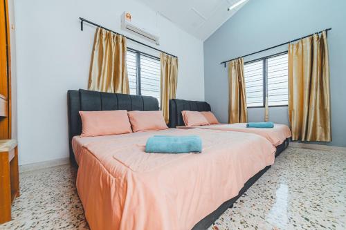 - une chambre avec 2 lits dotés d'oreillers roses et bleus dans l'établissement Batu Pahat w Pool table & Karaoke Villa 4BR16pax by Our Stay, à Batu Pahat