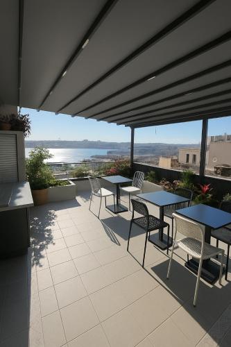 een terras met tafels en stoelen en uitzicht op de oceaan bij The Big Urban Stay in Istanbul