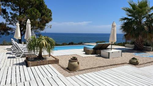 a patio with umbrellas and a swimming pool at La Pazienza in Marina di Gairo
