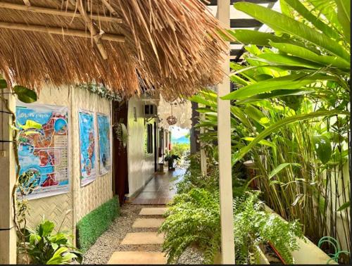 a walkway through a building with a straw roof at Panari Lodge El Nido in El Nido