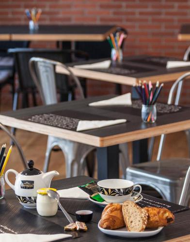 a table with a plate of bread and a cup of coffee at Hotel Balea in Guéthary