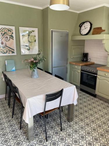 a kitchen with a table with a vase of flowers on it at Aux Petits Bonheurs in Grandcamp-Maisy