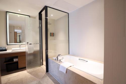 a bathroom with a bath tub and a sink at Hampton by Hilton Guangzhou Zhujiang New Town - Free Shuttle Bus to Canton Fair in Guangzhou