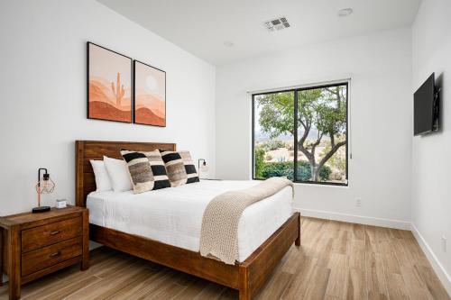 a white bedroom with a bed and a window at Mountain views swimming a private escape at Sonoran Serenity in Scottsdale