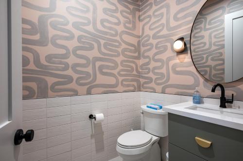 a bathroom with a toilet and a sink and a mirror at Mountain views swimming a private escape at Sonoran Serenity in Scottsdale