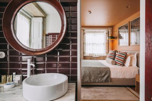 a bathroom with a large mirror and a bed and a tub at Gran Cruz House in Porto