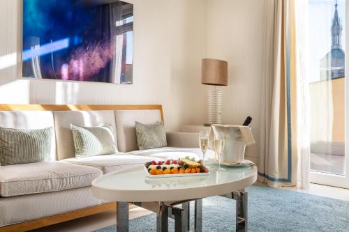 a living room with a couch and a table with a bowl of fruit at Meliá Genova in Genova