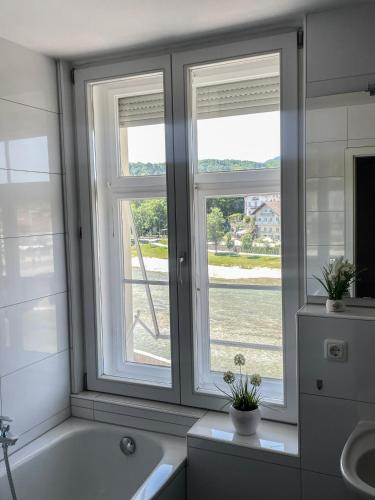 ein Badezimmer mit 2 Fenstern und einer Badewanne in der Unterkunft Fewo Isarblick Bad Tölz in Bad Tölz