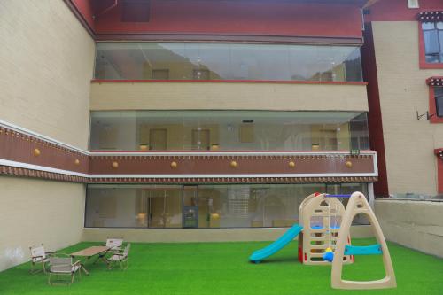 a playground in front of a building with a slide at 奇遇九寨之悦酒店Adventure Jiuzhai Hyatt Hotel in Jiuzhaigou