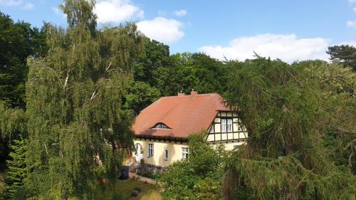 a house with a red roof in the woods at Dünenmeisterei Whg "Tulpe" in Ostseebad Koserow