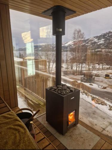 a wood fired stove in a room with a window at Luxurious holiday apartment with spectacular view in Flatland