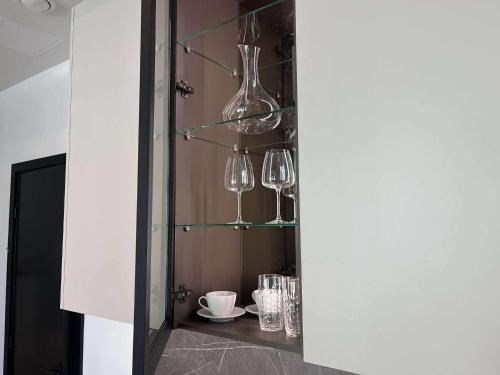 a cabinet filled with wine glasses and plates on display at Luise LuXe Suites in Tallinn