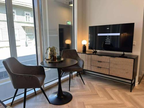a living room with a table and chairs and a tv at Luise LuXe Suites in Tallinn